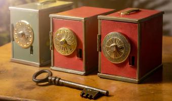 Three colored safes with a key lying in front of them symbolizing alternatives for Keycloak